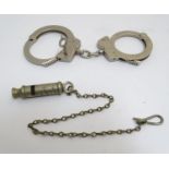 An early 20thC Metropolitan Police whistle by Shand Mason & Co. Together with 20thC Police handcuffs