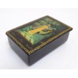 A 20thC Russian papier mache lacquered box with a hinged lid depicting a winter forest scene with