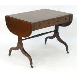 A Regency mahogany sofa table with drop flaps, with two short drawers and two sham drawers, having