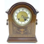 An Edwardian mahogany cased mantel clock, with Sheraton style inlays and enamelled dial. 10 3/4"