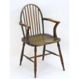 A late 18thC / early 19thC Windsor chair with a bowed back, swept arms, saddle seat and raised on