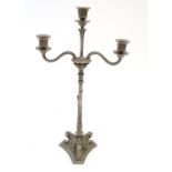 A Victorian silver plate three branch candelabra, with engraved armorial to base, lion's paw feet,