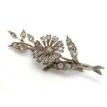 A brooch formed as a floral sprig set with white stones. 2 1/2" high Please Note - we do not make