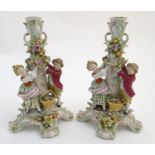 A pair of 19thC German figural lamp bases with two figures arranging flowers, raised on a
