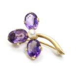 A late 19thC / early 20thC 9ct gold brooch set with amethysts and pearl in a stylised shamrock