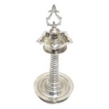 A white metal Indian Puja / Diya oil lamp, with 5 point reservoir to top, on a cylindrical stem with