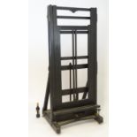 A late 19thC ebonised easel of large proportions , having a chamfered frame and moving on ceramic