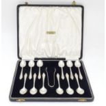A cased set of 12 silver coffee spoons with tongs ensuite. Hallmarked Birmingham 1936 (tongs) and