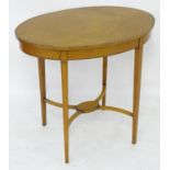 An early 19thc satinwood occasional table with an oval crossbanded top above four tapering legs