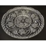 A large early 20thC cut glass charger, decorated with thistle, frond, star and rose cuts. 14" wide