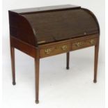 A late 18thC / early 19thC mahogany tambour fronted desk with a quarter cylinder top opening to show