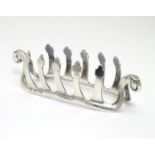 A silver toast / letter rack with shaped bars and scroll ends. Hallmarked London 1937 maker