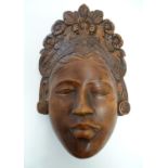 A Chinese carved wooden mask depicting a female face with a floral headdress. Approx. 10 3/4" Please