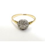 An 18ct gold ring set with central diamond bordered by 8 further diamonds in a cluster setting .