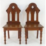 A pair of late 19thC pine Gothic chairs with quatrefoil decoration and pierced lancet decoration,