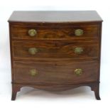 A Regency mahogany bow fronted chest of drawers with a feather banded and decoratively strung top