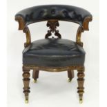 A mid 19thC mahogany captains chair with a deep buttoned leather backrest and leather upholstered