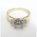 A 14ct gold ring with large central white stone flanked by two smaller stones. ring size approx Q