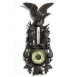 A late 19thC Black Forest barometer, the carved wooden case decorated with eagle, hanging game (