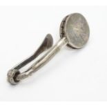 A silver napkin clip 1 3/4" long Please Note - we do not make reference to the condition of lots