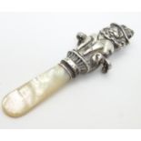A mother of pearl rattle teether the handle formed as a circus lion. Hallmarked 1940 maker