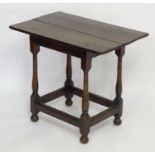 A 17thC and later side table with an overhanging top above four turned tapering legs terminating