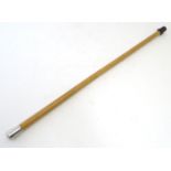 A walking cane with a malacca shaft and a white metal top. Approx. 33" Please Note - we do not