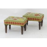 A pair of early 20thC mahogany footstools with upholstered tops and raised on turned tapering
