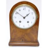 A 19thC arch top mantel clock, the flame mahogany case with boxwood and ebony stringing, enamelled