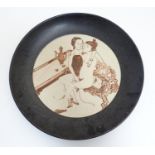 An Oriental plate / charger decorated with an erotic scene to centre. Approx. 13 1/2" diameter