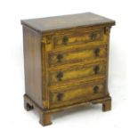 An early 20thC chest of drawers with a folding top above four drawers with drop handles and