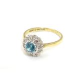 An 18ct gold ring set with central blue zircon bordered by diamonds. Ring size approx. M 1/2