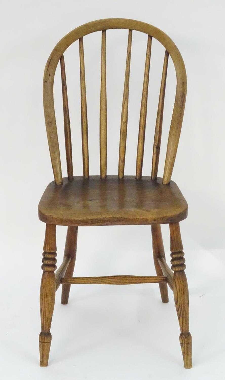 A 19thC elm childs Windsor chair with bowed back and stick supports above a shaped seat and raised - Image 2 of 4