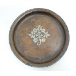 A Hugh Wallis Arts and Crafts hammered copper charger of circular form with silver plate floral