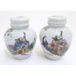 A pair of Oriental spice jars with lids and covers with hand painted decoration depicting two female