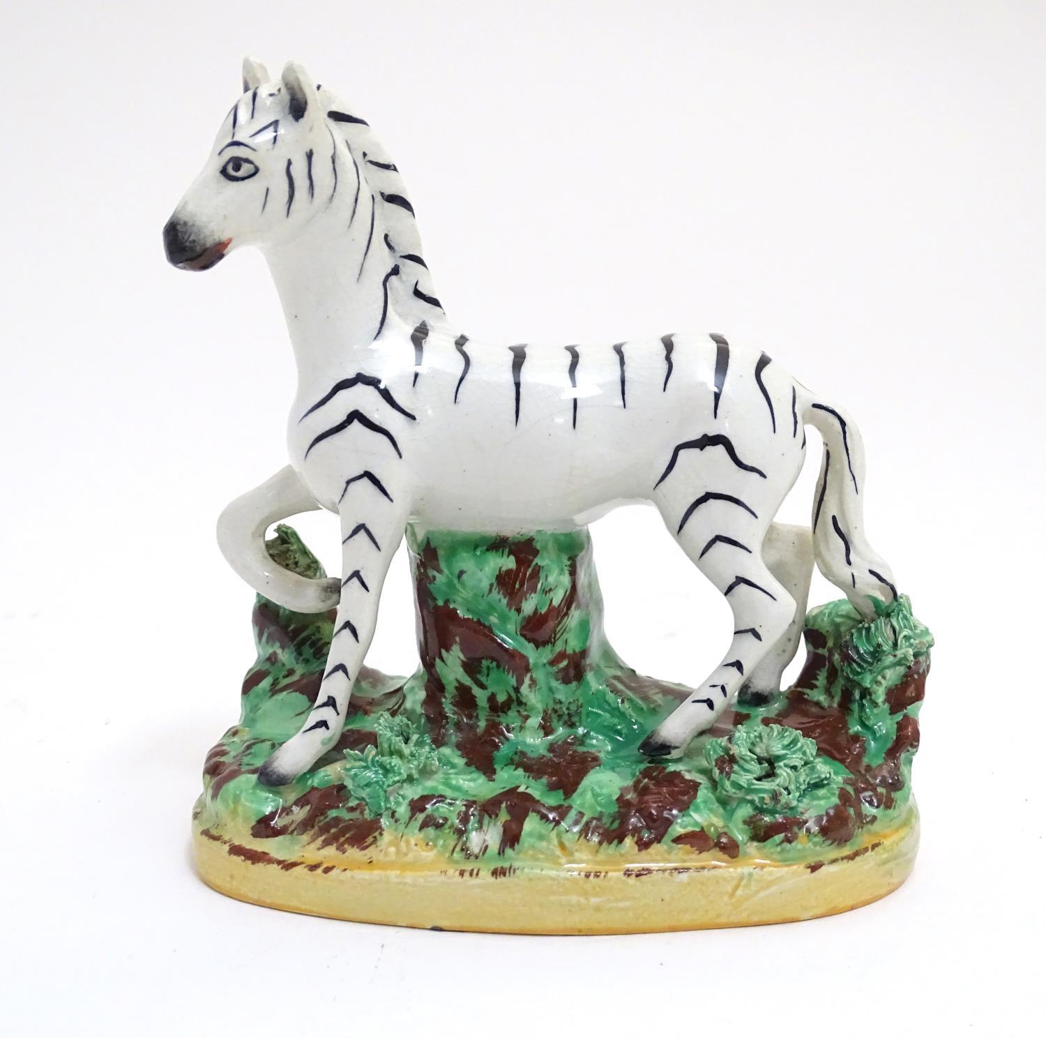 A Staffordshire figure modelled as a zebra on a naturalistic oval base. Approx. 4 3/4" high Please
