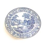 A blue and white pearlware cake stand decorated in the pattern The Angry Lion, depicting a landscape