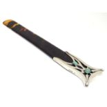 An Arts and Crafts tortoiseshell page turner with silver mounted handle with green cabochon detail