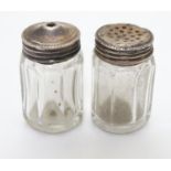 A pair of Sterling Silver lidded glass salt and pepper pots, each lid marked STERLING SILVER. Each