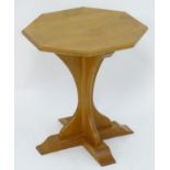 An early / mid 20thC oak Cotswold school table with an octagonal top above a chamfered frame and