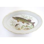 A French oval serving dish with a lobed rim, decorated with an underwater scene depicting a pike