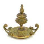 A 19thC cast inkwell the circular base decorated with mythical animal heads to include unicorns,