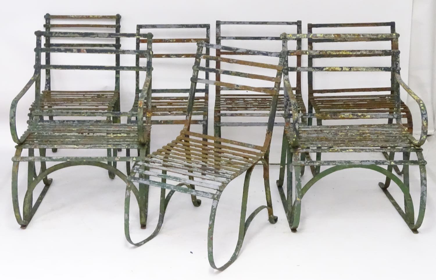 Seven Regency period garden chairs, these wrought iron strap back rails over a seat supported by 'S'
