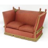 An early 20thC knoll sofa with drop ends, upholstered donkeys ears and ties terminating in
