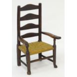 A late 18thC Georgian ladderback childs chair with an envelope rush seat and standing on squared
