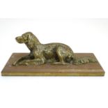 A late 19th / early 20thC cast paperweight formed as a recumbent dog on a rectangular plinth.