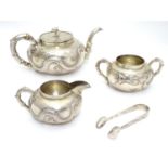 Chinese Export silver : A white metal three piece teaset comprising teapot, milk jug and sugar