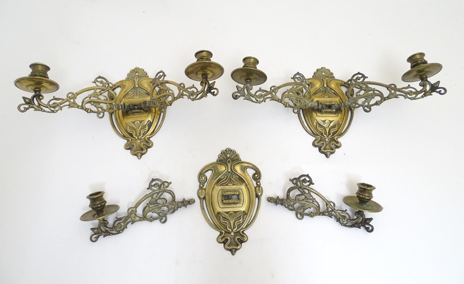 A trio of 19thC brass adjustable double wall sconces, decorated with acanthus fronds and elements of