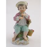A Continental porcelain figure of a boy playing a musical instrument, seated on a naturalistic