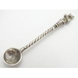 A white metal salt spoon, the handle surmounted by a bear 2 3/4" long Please Note - we do not make